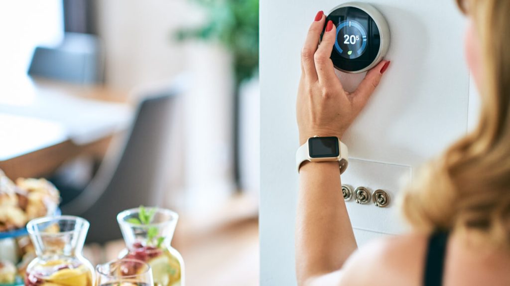 woman turning up thermostat