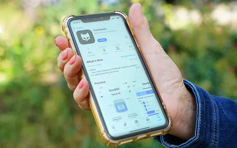 A mobile phone showing the FoxMobile app for heating oil management.