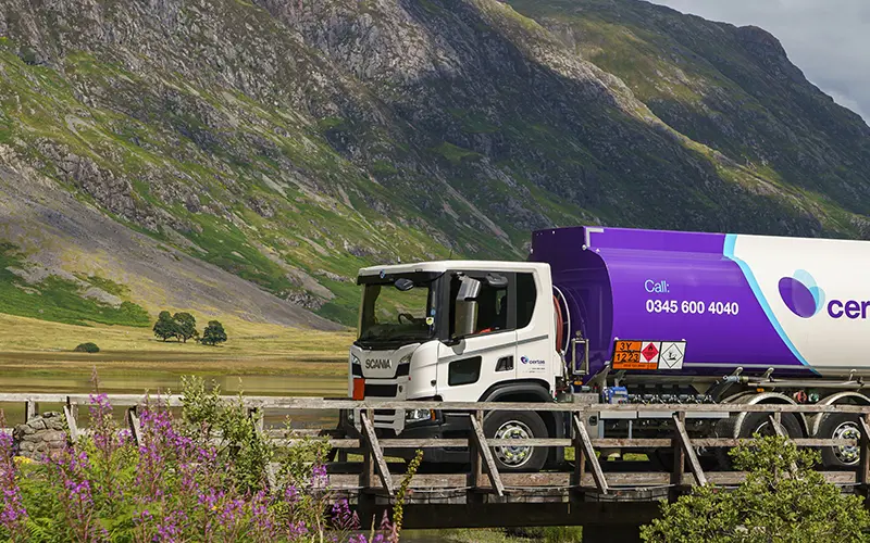Certas Energy delivery truck driving through mountainous countryside.
