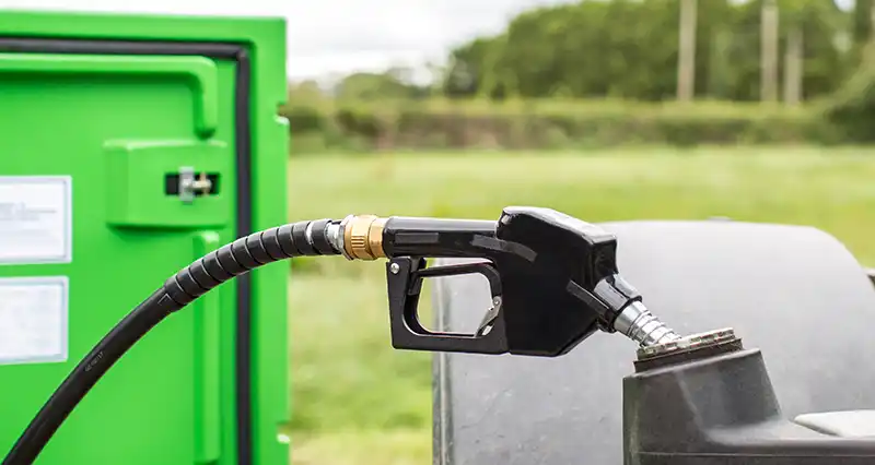 Diesel nozzle from commercial fuel tank filling a tractor.