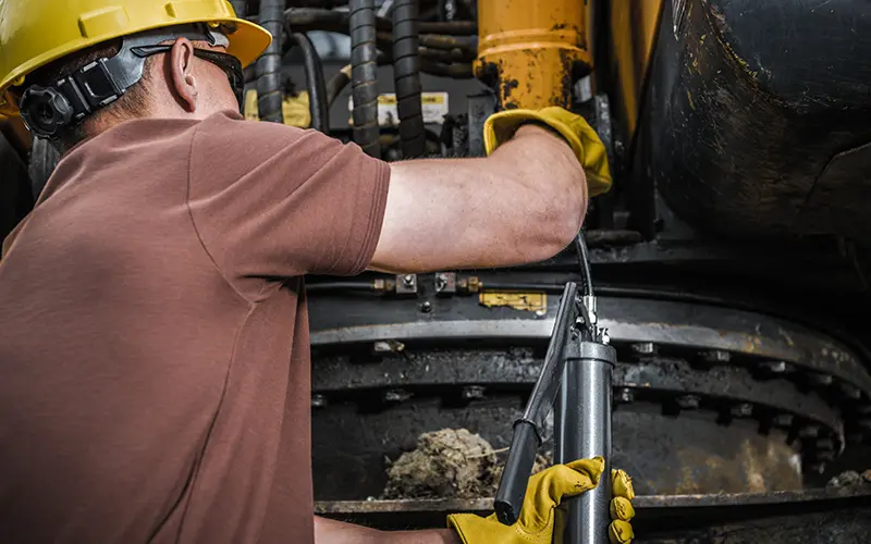 Man working with machinery that requires lubricant.