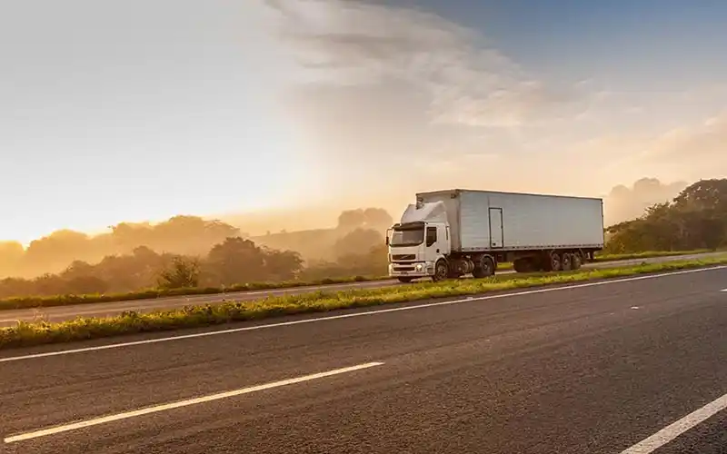 White lorry on motorway at dusk.