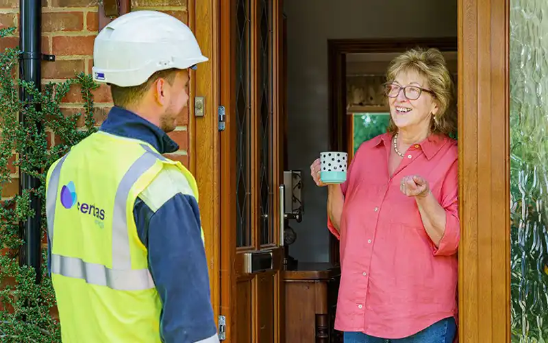 Lady answering front door to a boiler service man from Certas Energy.