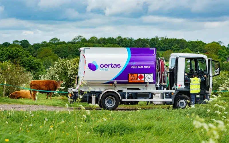 Certas Energy tanker on a track in a field with cows around.